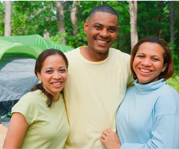 Three adults smiling outside